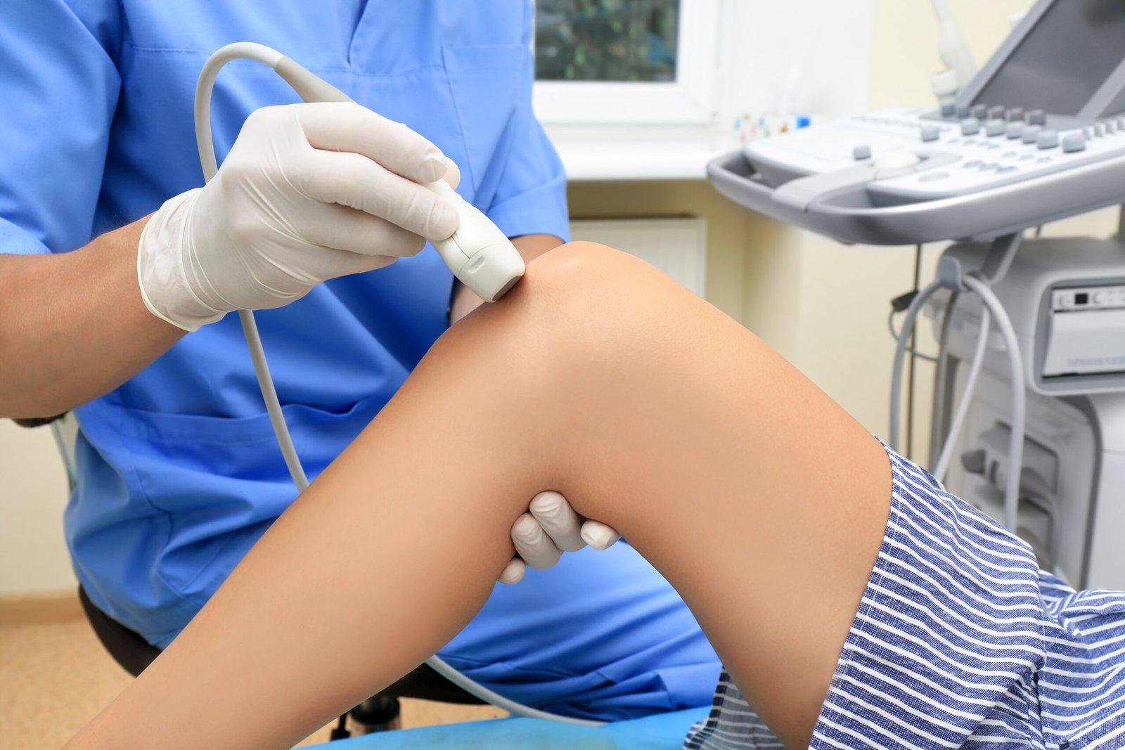 doctor-conducting-ultrasound-examination-patient-s-knee-clinic