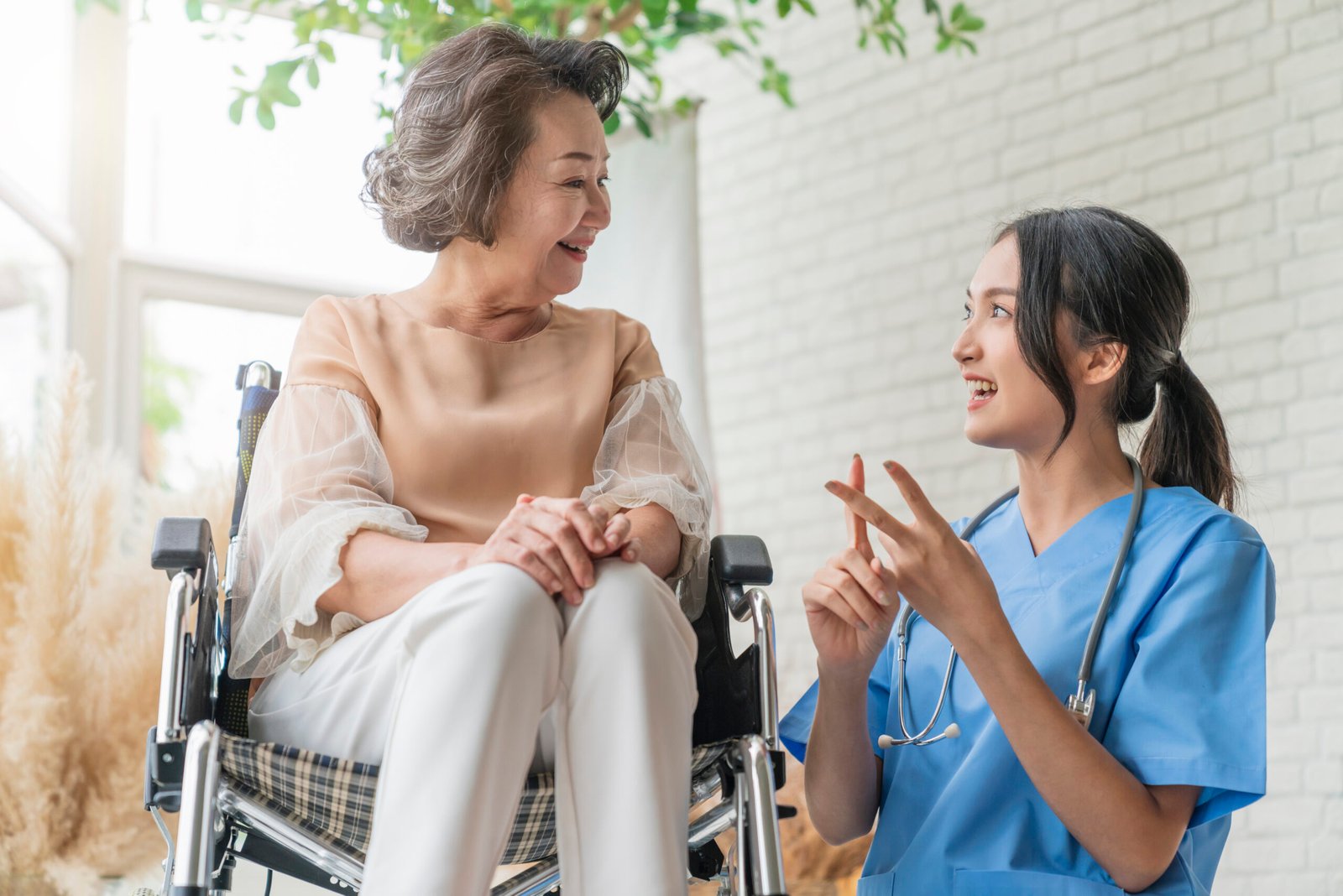 Total vs Partial Knee Replacement: Which Do You Need? 2 asian young caregiver caring her elderly patient senior daycare handicap patient wheelchair hospital talking friendly nurse looking cheerful nurse wheeling senior patient scaled