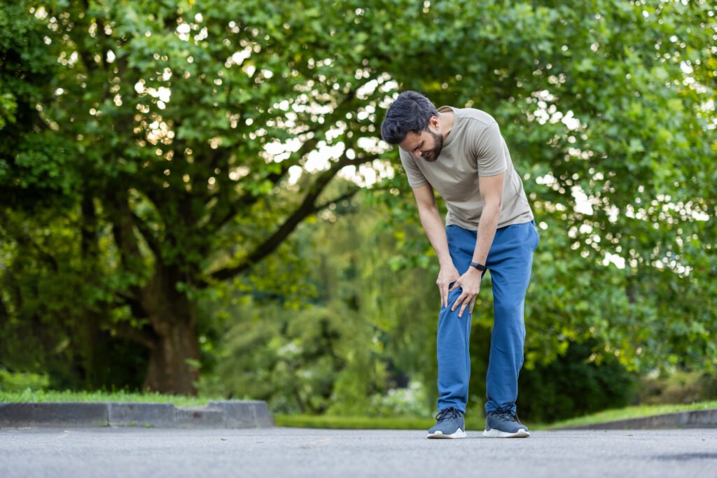 How Long Does a Knee Replacement Last? Implant Lifespan Explained 10 athlete pauses workout due leg injury standing outdoors peaceful park person appears be