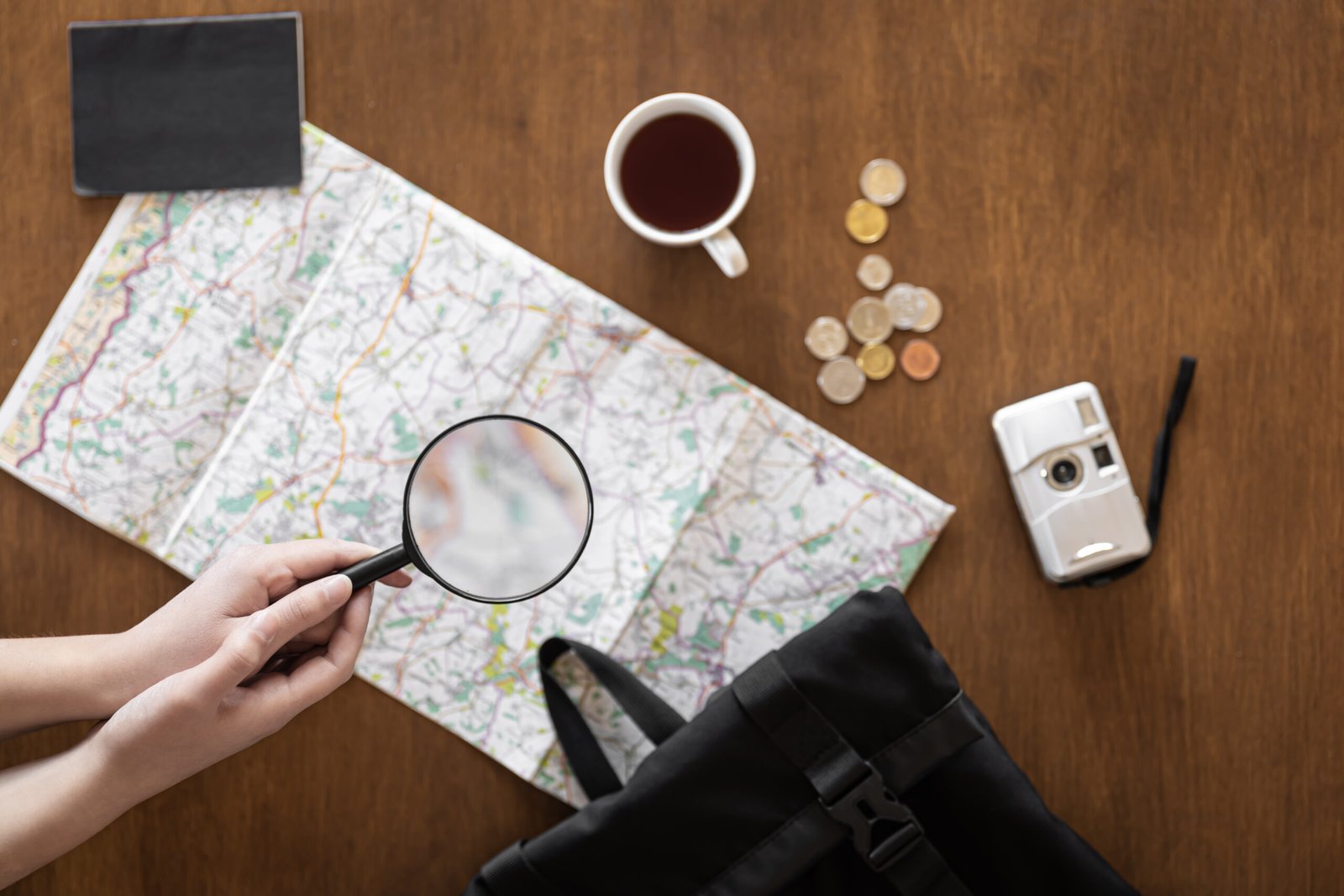 flat-lay-magnifier-female-hands-map-documents-money-camera-cup-coffee-travel-planning-concept